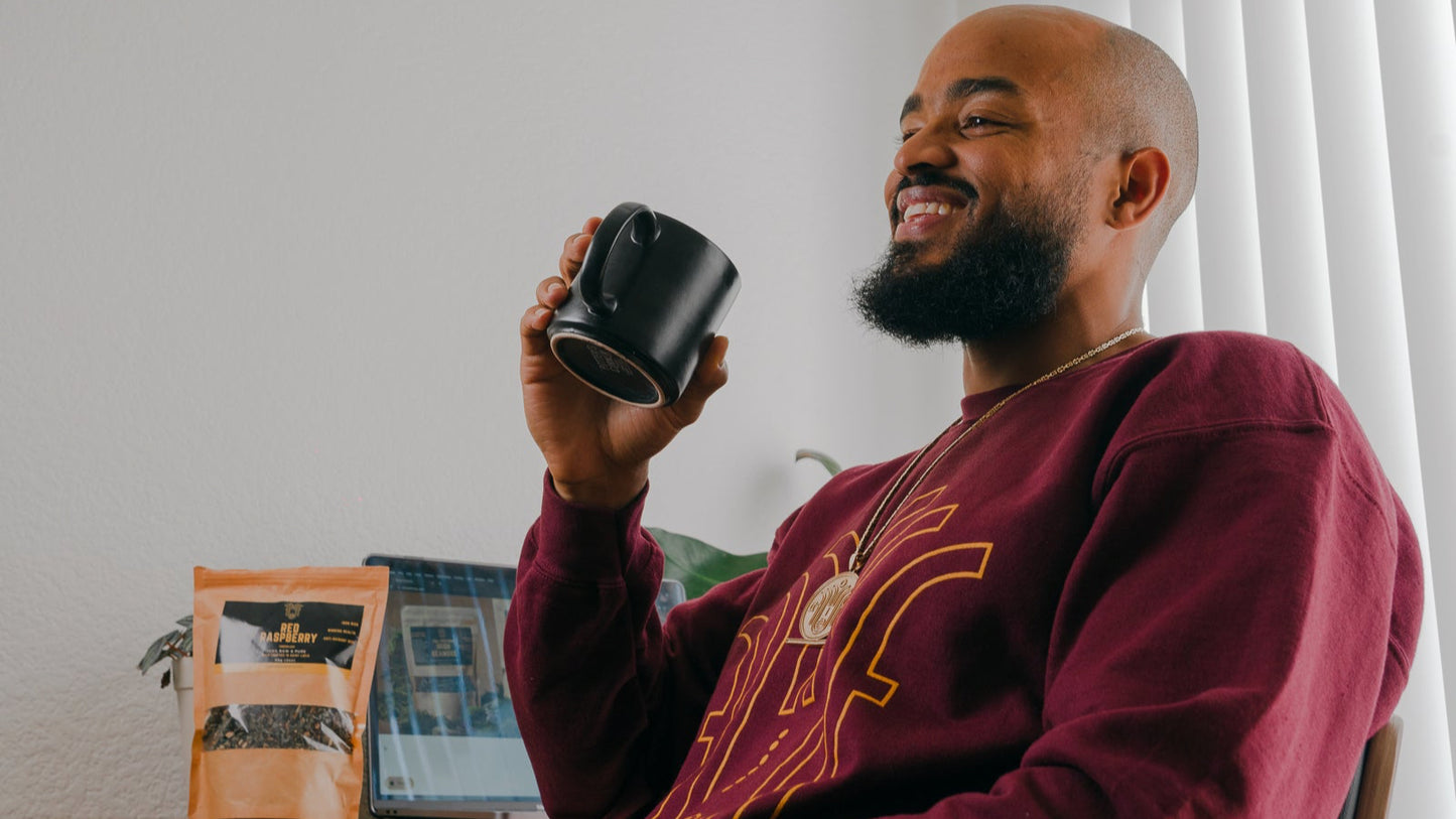 Man holding a black mug in a home office setting